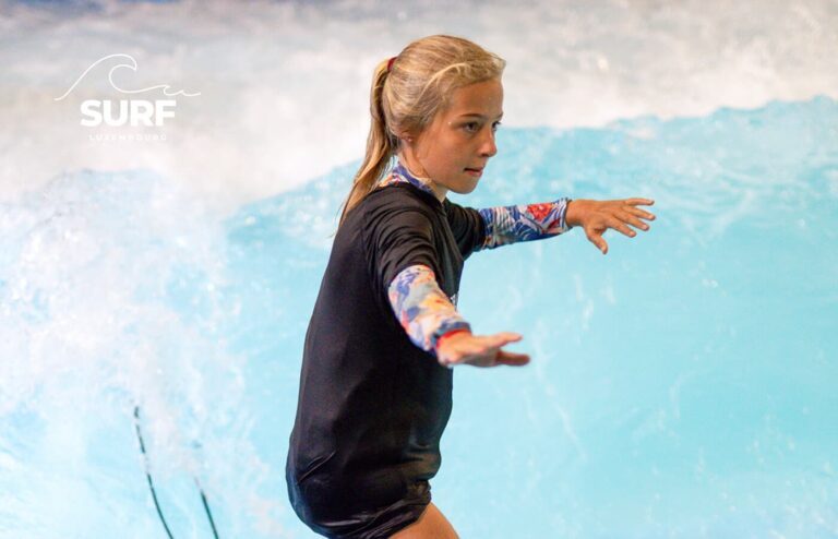 Jeune fille surfant sur la vague indoor de Surf Luxembourg au Van der Valk Luxembourg